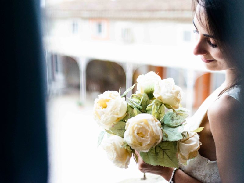 une mariée au bouquet à la fenêtre du château de Riveneuve