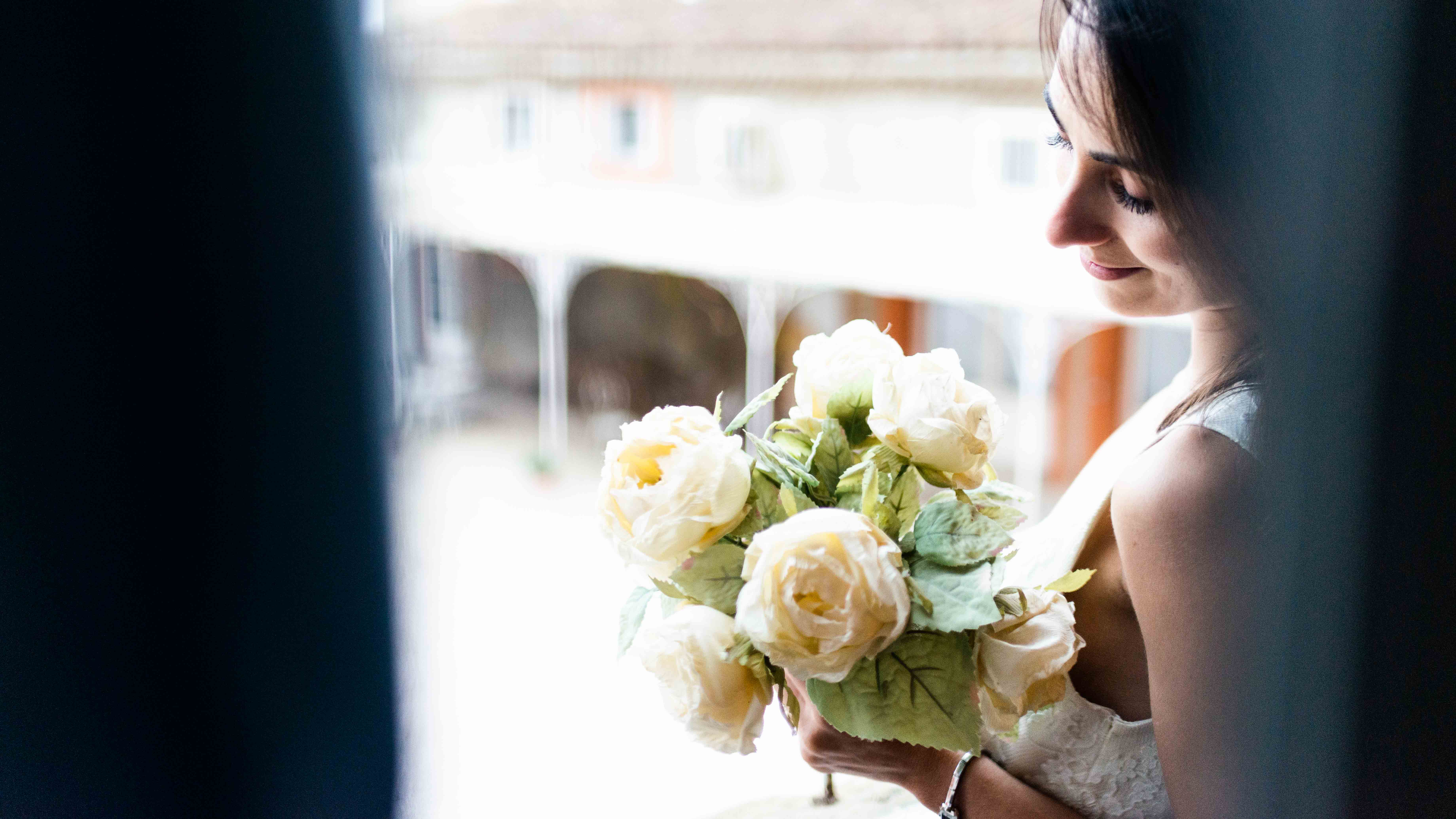 une mariée au bouquet à la fenêtre du château de Riveneuve