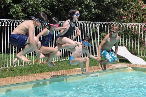 Enfants en vacances qui sautent dans la piscine