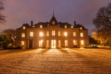 La façade principale du château la nuit.