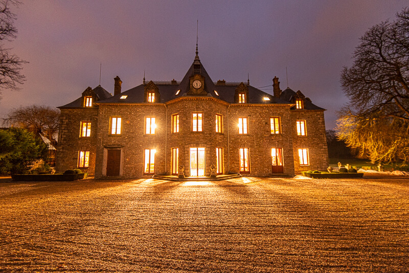 La façade principale du château la nuit.