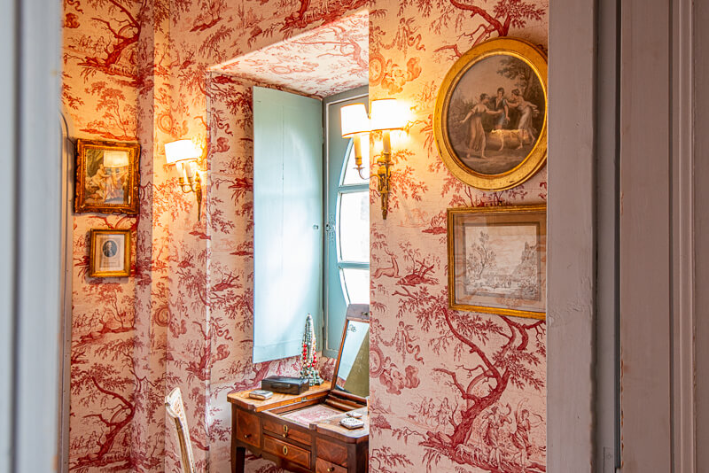 Les murs plaqués de papier peint aux motifs rouges et à la décoration ancienne