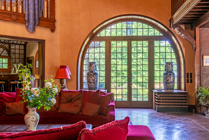 Une porte vitrée menant vers le jardin du château, bordée par deux vases en céramiques