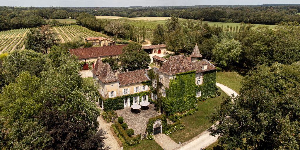 Chateau de Briat, Facade by drone, elegant family home, part of which was the royal hunting lodge of King Henry IV, outdoor pool and tennis court, located in the family vineyard of Armagnac, exclusive rental.