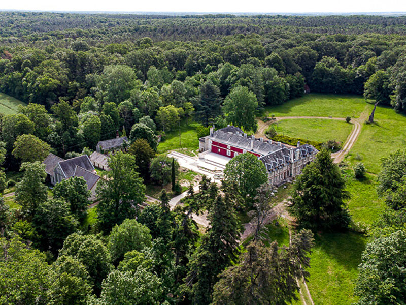 Vue aérienne du château de montgoger au milieu de son parc boisé