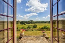 Vue sur la terrasse et les paysages du Charolais depuis la salle à manger - séjour dans un château à louer proche de Lyon